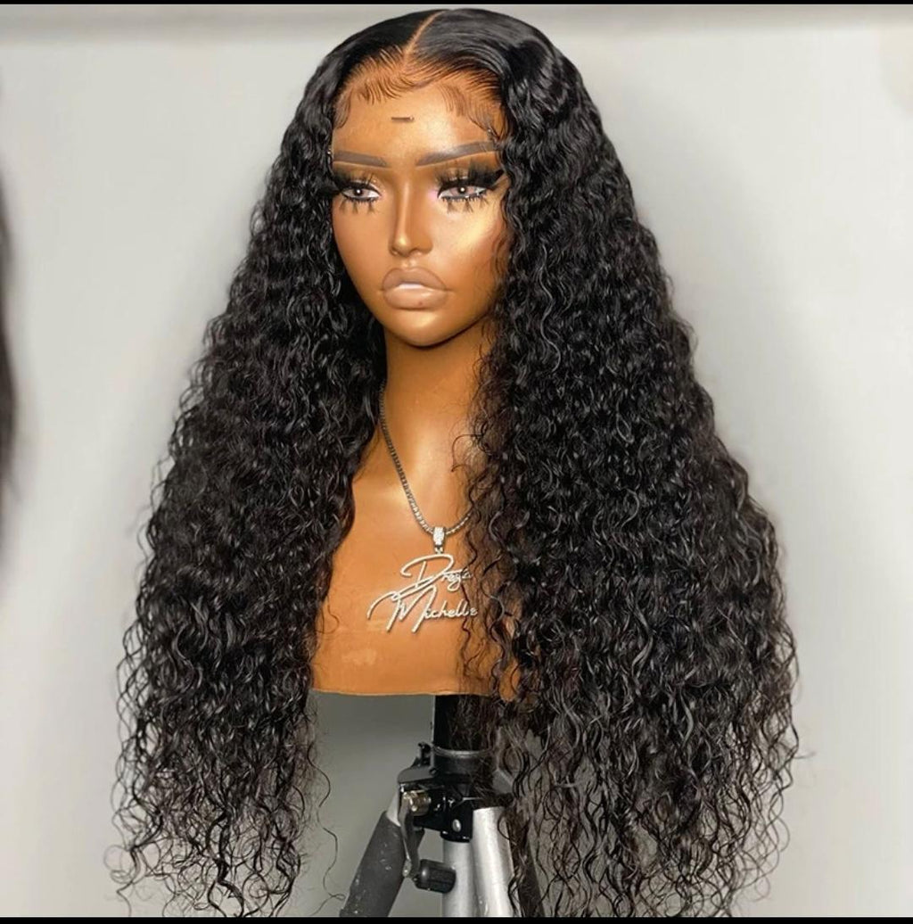 Mannequin head with long, black, wavy wig on a white background