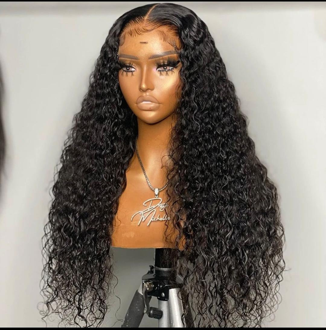 Mannequin head with long, black, wavy wig on a white background